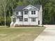 Well-maintained two-story home with gray siding, a welcoming front porch, and a newly installed driveway at 266 Fast Pitch Ln, Four Oaks, NC 27524