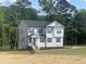 Two-story home with gray siding and black shutters featuring a well-manicured lawn and tidy landscaping at 266 Fast Pitch Ln, Four Oaks, NC 27524