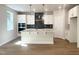 Spacious open kitchen with stainless steel appliances, white cabinetry, and quartz countertops on a large center island at 266 Fast Pitch Ln, Four Oaks, NC 27524