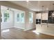 Open-concept living area adjoining a modern kitchen, filled with natural light from large windows at 266 Fast Pitch Ln, Four Oaks, NC 27524