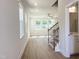 Bright living room with hardwood-style floors, staircase, and natural light streaming through large windows at 266 Fast Pitch Ln, Four Oaks, NC 27524