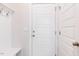 A well-lit mudroom features a white built-in bench and storage area with coat hooks and a door at 266 Fast Pitch Ln, Four Oaks, NC 27524