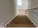 View down the wood staircase showing natural light and neutral walls at 266 Fast Pitch Ln, Four Oaks, NC 27524