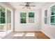 Bright sunroom featuring wood floors, large windows with a view of lush greenery, and a sliding glass door at 266 Fast Pitch Ln, Four Oaks, NC 27524
