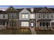 Charming townhome featuring stone accents, a welcoming entrance, and manicured landscaping at 951 Alma Railway Dr # 561, Wake Forest, NC 27587