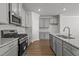 Modern kitchen with gray cabinetry, stainless steel appliances, and granite countertops at 951 Alma Railway Dr # 561, Wake Forest, NC 27587
