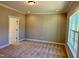 Cozy bedroom featuring plush carpeting, neutral walls, and a window for natural light at 1044 Fairhaven Dr # 100, Mebane, NC 27302