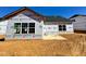 New construction exterior with builder's wrap showcasing window placement and home structure at 1044 Fairhaven Dr # 100, Mebane, NC 27302