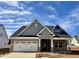 New construction home boasts a two-car garage, stone accents, and inviting entryway at 1044 Fairhaven Dr # 100, Mebane, NC 27302