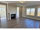 Bright living room with a fireplace, large windows offering lots of natural light, and hardwood floors at 1044 Fairhaven Dr # 100, Mebane, NC 27302