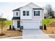 Charming two-story home featuring a 2-car garage, manicured lawn, and stylish black and white accents at 305 Little Creek Dr, Lillington, NC 27546