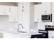 Modern kitchen features white cabinetry and island with pendant lighting at 305 Little Creek Dr, Lillington, NC 27546