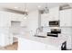 Modern kitchen features white cabinetry and island with pendant lighting at 305 Little Creek Dr, Lillington, NC 27546