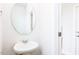 Powder room featuring a pedestal sink and a round mirror at 305 Little Creek Dr, Lillington, NC 27546