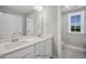 Bathroom with double sinks, stone countertops, large mirror and white cabinets at 34 Macy Cir, Wendell, NC 27591