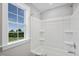 Bright bathroom with white tub, shower combination, and window with a backyard view at 34 Macy Cir, Wendell, NC 27591
