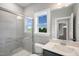 Modern bathroom featuring a tiled shower with glass doors and a bright window at 34 Macy Cir, Wendell, NC 27591