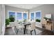 Bright dining room features large windows, stylish chandelier, and modern glass table at 34 Macy Cir, Wendell, NC 27591