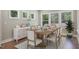 Bright dining room with rustic table, six chairs, sideboard, and large windows at 34 Macy Cir, Wendell, NC 27591