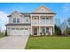 Charming two-story home with grey siding, white trim, front porch, and attached two-car garage at 34 Macy Cir, Wendell, NC 27591