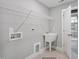 Well-equipped laundry room featuring a utility sink, storage rack, and modern fittings for convenience at 34 Macy Cir, Wendell, NC 27591