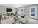 Bright living room with two chairs, a sofa, TV, and a glass coffee table at 34 Macy Cir, Wendell, NC 27591