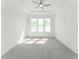 Bright bedroom with large window, ceiling fan, and neutral carpet at 624 Gainer Dr # 17, Raleigh, NC 27610