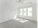 Bright bedroom with large window, ceiling fan, and neutral carpet at 624 Gainer Dr # 17, Raleigh, NC 27610
