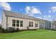 Backyard with green grass and newly planted shrubs, exterior view of windows, and a gray roof at 205 Mugby Rd # 173, Raleigh, NC 27610