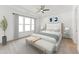 A serene main bedroom features a large bed, ceiling fan, bedside tables, and an abundance of natural light at 205 Mugby Rd # 173, Raleigh, NC 27610