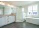 Luxurious bathroom with modern tub, glass shower, double vanity, and tiled floor at 100 Mossy Falls Way, Wendell, NC 27591
