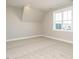 Bright carpeted bedroom with a sloped ceiling and a large window at 100 Mossy Falls Way, Wendell, NC 27591