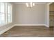 Bright dining room showcasing a modern chandelier, large windows, and beautiful flooring at 100 Mossy Falls Way, Wendell, NC 27591