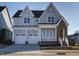 Two-story home featuring a two car garage, brick accents, and a covered front porch at 100 Mossy Falls Way, Wendell, NC 27591