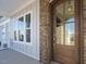 Close-up of the wood front door, brick accents, and a covered porch at 100 Mossy Falls Way, Wendell, NC 27591