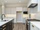 Modern kitchen featuring a black center island, stainless steel appliances, and pendant lighting at 100 Mossy Falls Way, Wendell, NC 27591