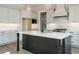 Bright kitchen with white countertops, light gray cabinets, subway tile backsplash, and black island at 100 Mossy Falls Way, Wendell, NC 27591