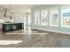 Living room with a kitchen view, black center island, and a wall of large windows at 100 Mossy Falls Way, Wendell, NC 27591