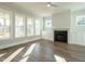 Spacious living room featuring large windows, modern fireplace, and built-in cabinets at 100 Mossy Falls Way, Wendell, NC 27591