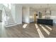 Open-concept living room with modern staircase and hardwood floors flows into a stylish kitchen with island at 100 Mossy Falls Way, Wendell, NC 27591