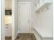 Mudroom featuring a built-in bench with storage, hooks, and access to the kitchen and exterior door at 100 Mossy Falls Way, Wendell, NC 27591
