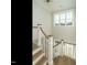 Well-lit staircase with wooden treads, white risers and railing, leading to the upper level at 100 Mossy Falls Way, Wendell, NC 27591