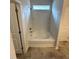 Bathroom featuring a tiled tub-shower combination, bright natural light, and neutral color palette at 216 Bruce Dr, Dunn, NC 28334