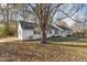 Side view of a charming single-story home with a large shade tree and a driveway at 234 Crumpler Rd, Kenly, NC 27542