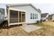 Home's backyard showcasing the screened porch and concrete patio, enhanced by fresh landscaping at 1253 Barreto Dr, Wendell, NC 27591
