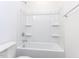 Bright white bathroom featuring a shower-tub combo with built-in shelving at 1253 Barreto Dr, Wendell, NC 27591