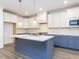 Well-equipped kitchen with white upper cabinets, blue lower cabinets, and a spacious island at 1253 Barreto Dr, Wendell, NC 27591