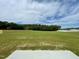 Large, open backyard with lush green grass, bordered by a wooden fence and mature trees, under a bright sky at 158 Citizens Ct # 32, Four Oaks, NC 27524