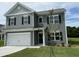 Inviting two-story home with gray siding, black shutters, and a well-manicured lawn with a newly planted tree at 158 Citizens Ct # 32, Four Oaks, NC 27524
