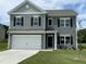 Charming two-story home featuring gray siding, black shutters, and a two-car garage on a well-maintained lawn at 158 Citizens Ct # 32, Four Oaks, NC 27524